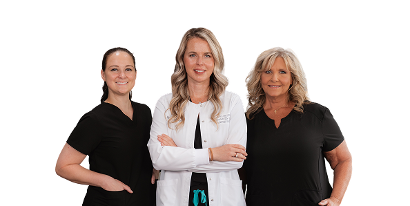 Three smiling female healthcare professionals pose together against a black background, wearing black and white uniforms, conveying warmth and confidence.